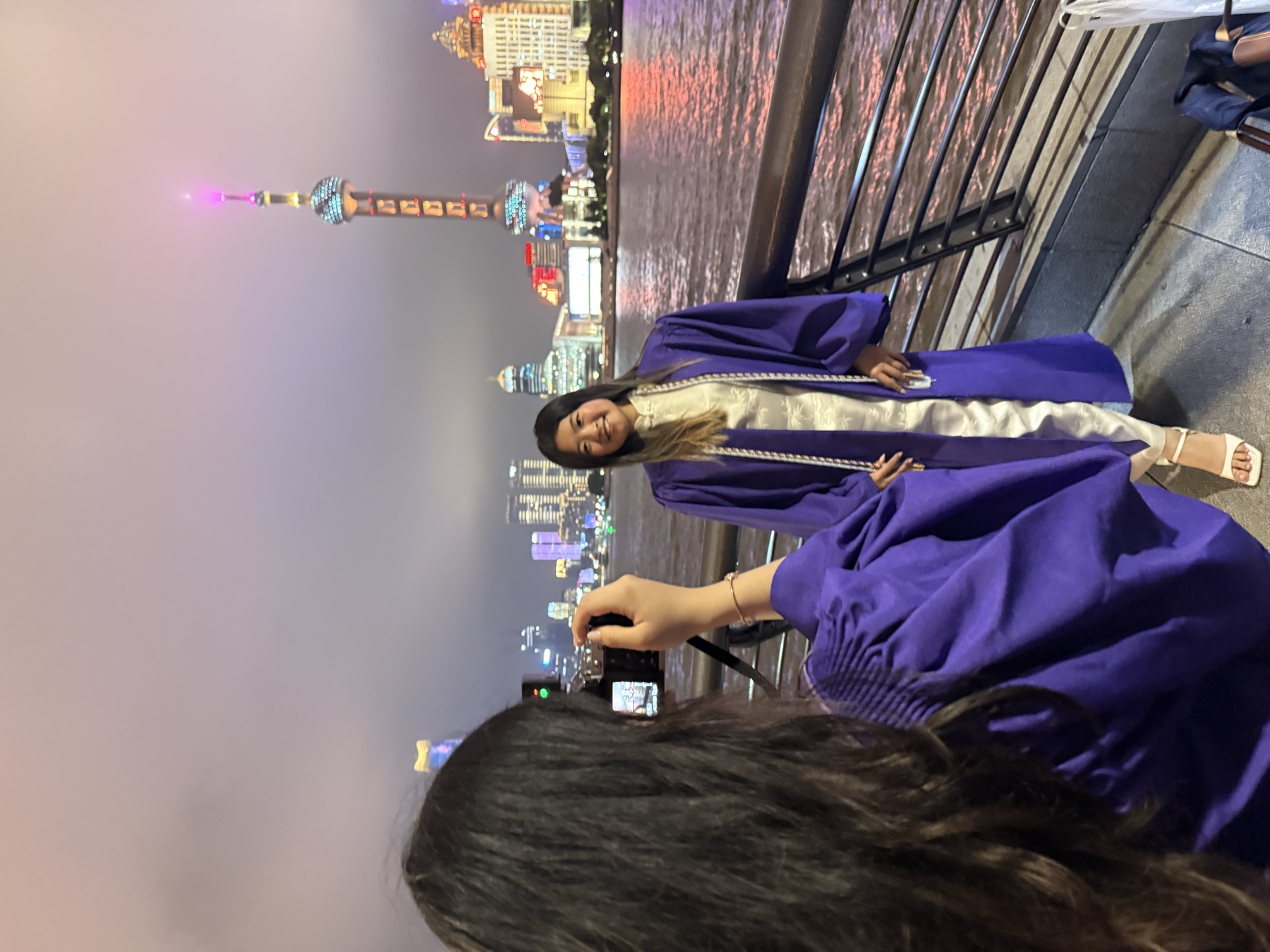 Tina at her graduation on the Bund in Shanghai, with the Oriental Pearl Tower skyline behind her